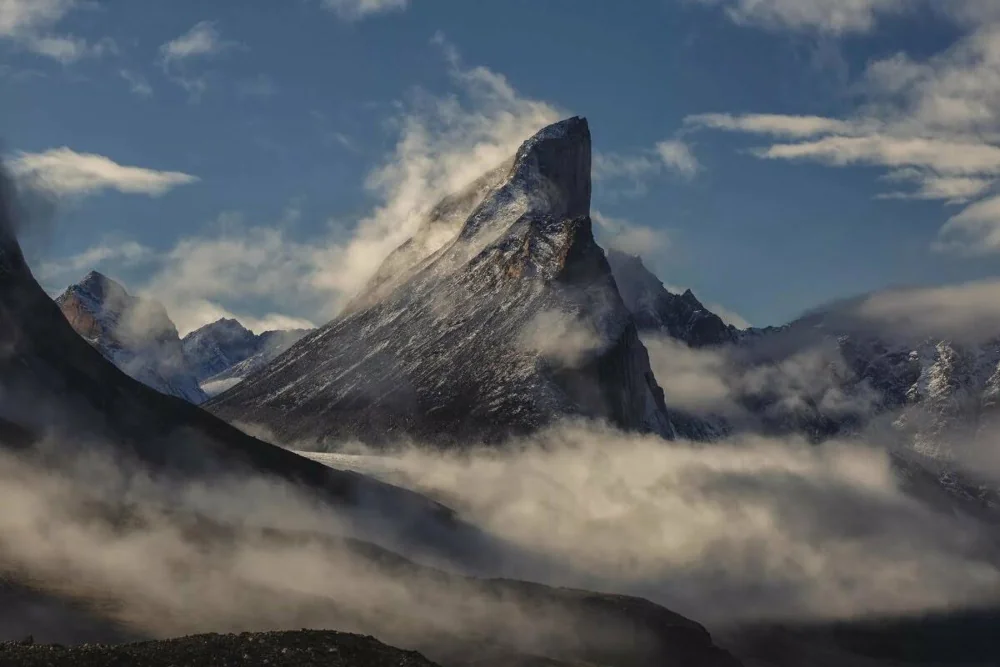 Snowy mountain peak with clouds
